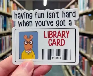 Image shows popular kid's cartoon and book series main character, Arthur. His picture is on his library card with a caption that says "having fun isn't hard when you've got a library card"