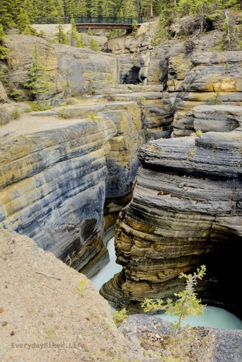 Looking downstream from the falls into the layers of Mistaya canyon.  The pedestrian bridge spans the top of the frame.