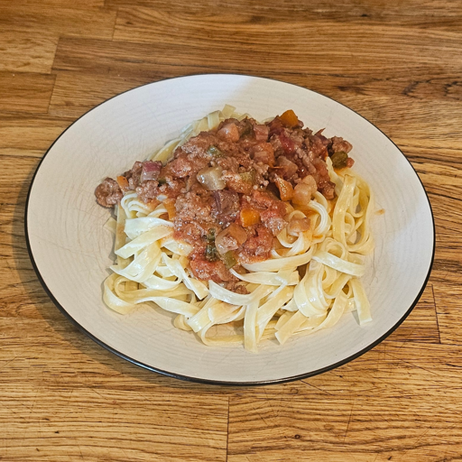 A plate of creamy pasta with bolognese sauce