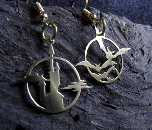 Brass earrings showing a vampire-like castle on one side, and a swarm of bats on the other