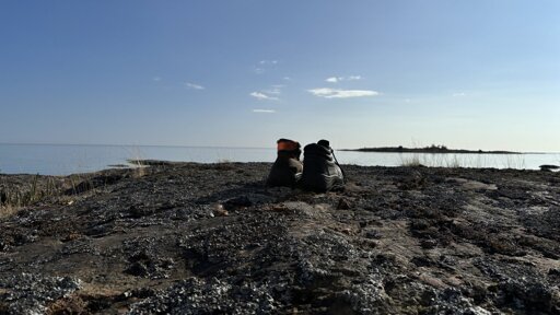 Photo of a pair of boots on a cliff with a view out over the water.